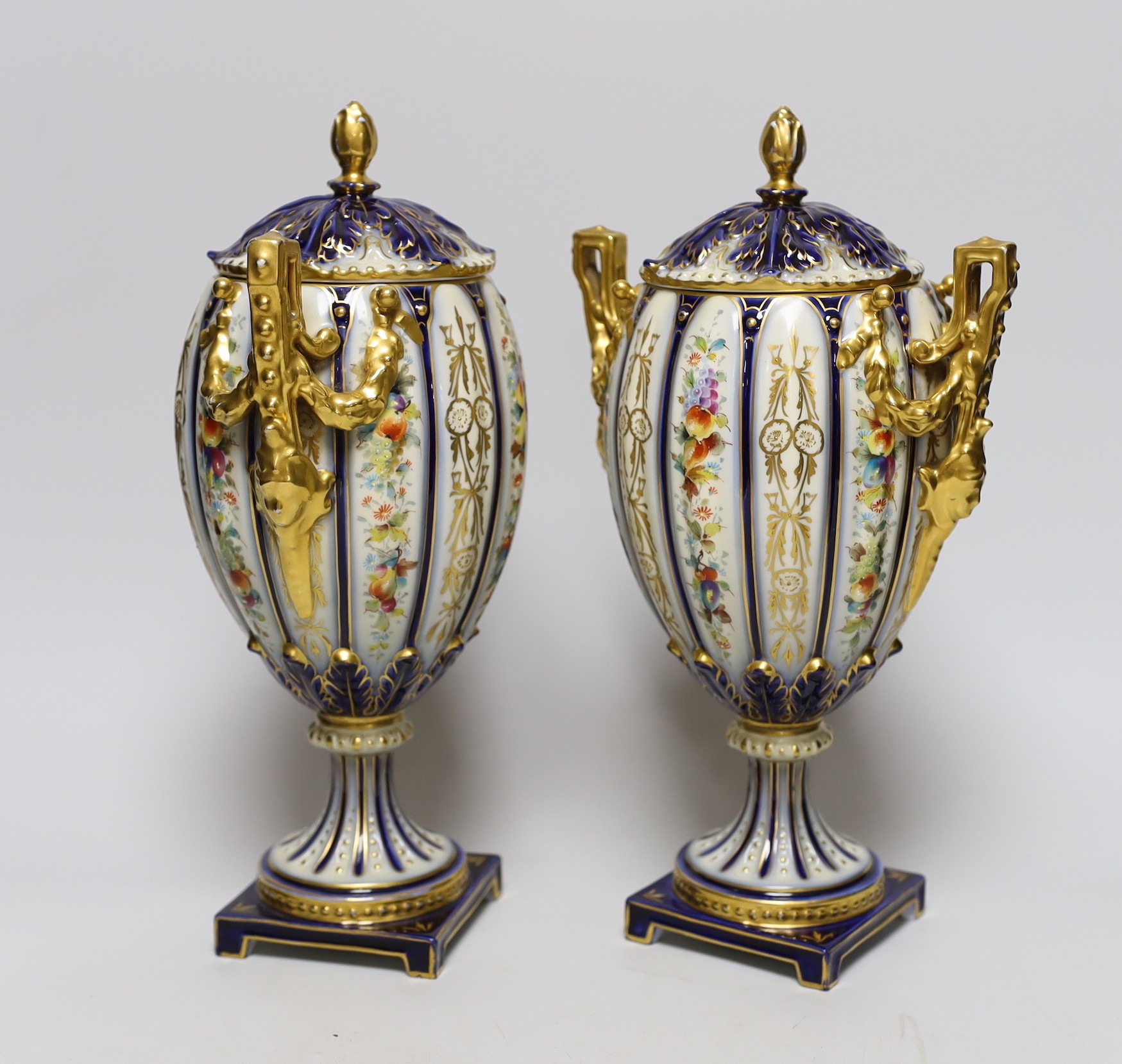 A pair of 19th century continental porcelain gilt and floral urns and covers, 29cms high
